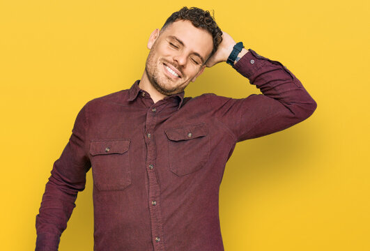 Young hispanic man wearing casual clothes stretching back, tired and relaxed, sleepy and yawning for early morning