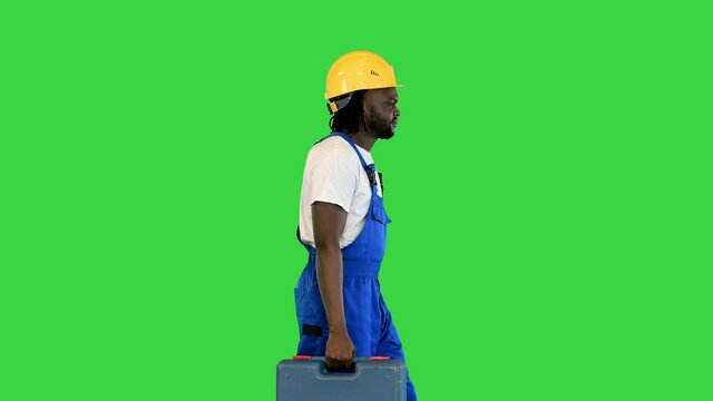 Young construction worker going off to work on a Green Screen, Chroma Key.