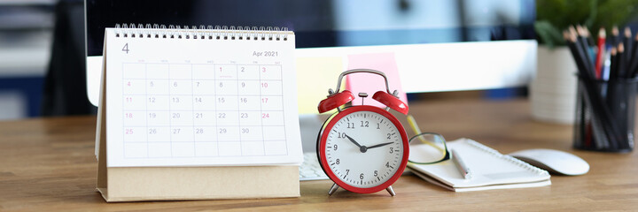 Fototapeta na wymiar Red alarm clock and calendar for 2021 on desktop