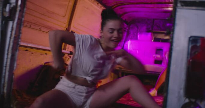 4K Stylish, funny sexy girls dancing , moving , having fun inside old abandoned minibus . White party . Girl dancer dances on the roof of car or bus . Beautiful women smiling, laughing on white shorts