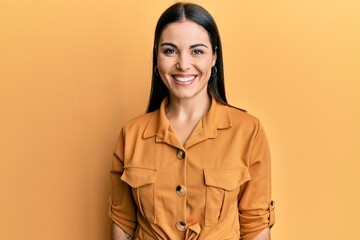 Young brunette woman wearing casual clothes looking positive and happy standing and smiling with a...