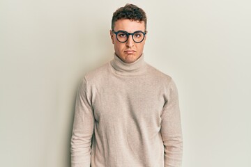 Hispanic young man wearing casual turtleneck sweater depressed and worry for distress, crying angry and afraid. sad expression.