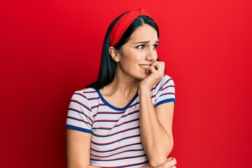 Young hispanic woman wearing casual clothes looking stressed and nervous with hands on mouth biting nails. anxiety problem.