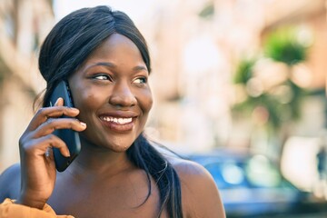 Young african american woman smiling happy talking on the smartphone at the city.