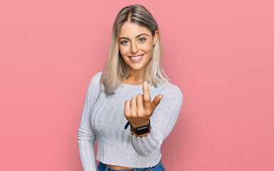 Beautiful blonde woman wearing casual clothes beckoning come here gesture with hand inviting welcoming happy and smiling - obrazy, fototapety, plakaty