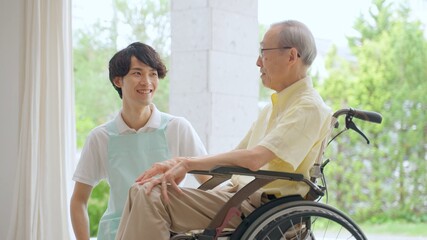 Fototapeta na wymiar 車椅子に乗った高齢者と介護士