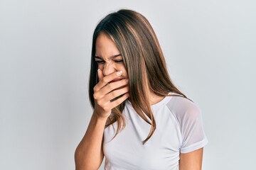 Young brunette woman wearing casual white t shirt feeling unwell and coughing as symptom for cold or bronchitis. health care concept.