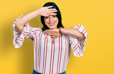 Young hispanic girl wearing casual clothes smiling cheerful playing peek a boo with hands showing face. surprised and exited