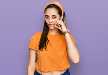 Young hispanic woman wearing casual clothes mouth and lips shut as zip with fingers. secret and...