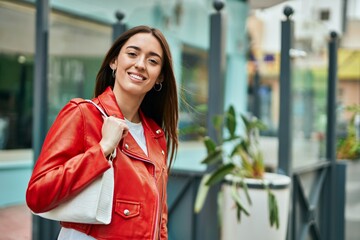 Young hispanic woman smiling happy standing at the city.