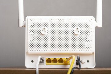 Backside of modern white wireless internet router with cables and DSL wire
