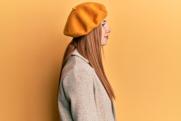 Young irish woman wearing french look with beret looking to side, relax profile pose with natural face with confident smile.
