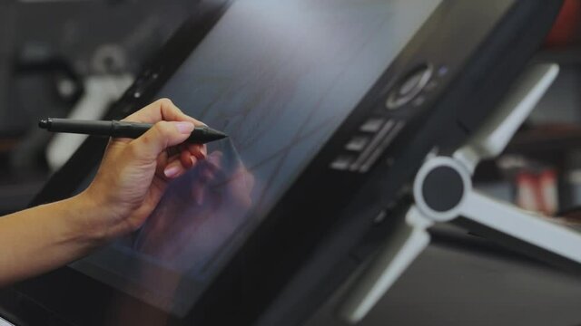 Drawing on a graphics tablet. The designer draws on a graphics tablet. Working with interactive pen display. closeup. Wallpaper production.