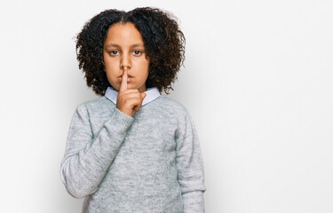 Fototapeta na wymiar Young little girl with afro hair wearing casual clothes asking to be quiet with finger on lips. silence and secret concept.