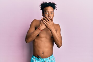 Fototapeta premium Young african american man with beard wearing swimsuit shocked covering mouth with hands for mistake. secret concept.