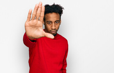 Young african american man with beard wearing casual winter sweater doing stop sing with palm of...