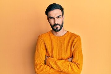 Young hispanic man wearing casual clothes skeptic and nervous, disapproving expression on face with crossed arms. negative person.