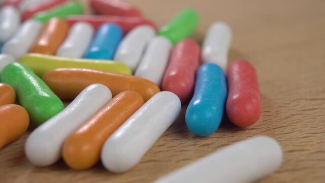 Bright colourful sweets on a wooden surface. Macro. Dolly shot. Multicolored kids dessert with glaze. Oblong shape