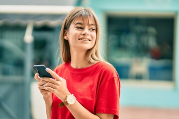 Caucasian teenager girl smiling happy using smartphone at the city.