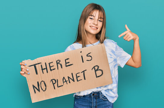 Teenager caucasian girl holding there is no planet b banner smiling happy pointing with hand and finger