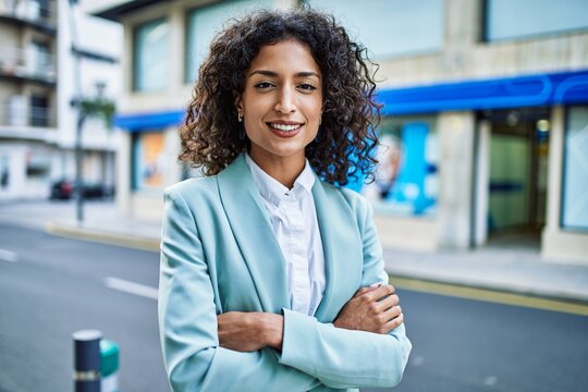 Young hispanic business woman wearing professional look smiling confident at the city