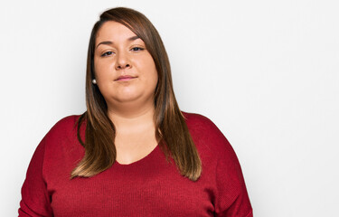 Fototapeta premium Beautiful brunette plus size woman wearing casual clothes relaxed with serious expression on face. simple and natural looking at the camera.