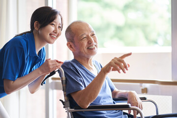 車椅子に乗る高齢者と介護士