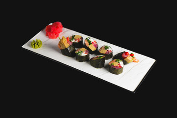Maki Sushi set on a white plate over black background. Japanese cuisine concept, maki rolls.