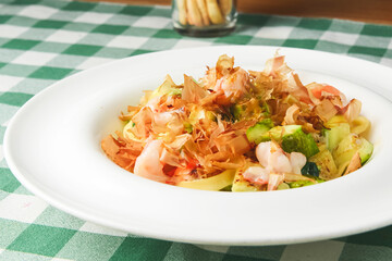 Spaghetti with shrimps, tuna shavings, and vegetables - zucchini, cucumbers, avocado.