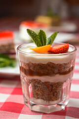 Layered dessert with fruits and cream cheese in glass jar. Sour and whipped cream dessert with fresh strawberry