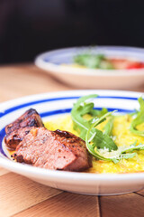 Risotto with pork sausages with cherry tomatoes and parsley on a plate. Italian cuisine concept