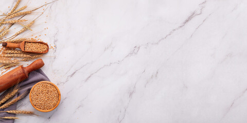 Wheat ears and wheat grains set up on marble background. Top view and copy space
