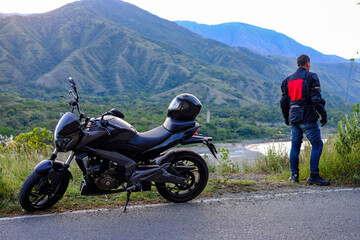 person on motorcycle traveling between mountains