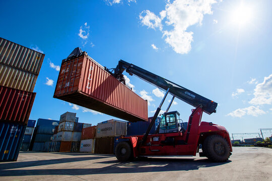 Summer, 2017 - Vladivostok, Primorsky region - Container terminal. A reachstacker transports a large container through a logistics warehouse.