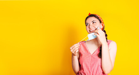 A beautiful smiling girl, takes off her mask after completing the mask mode, dressed in a summer...