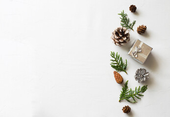 Winter background with pine cones, evergreen twigs and silver box. Flat lay. Copy space