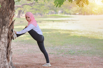 Public exercise lifestyle concept, fitness woman listening music from wireless earphones and mobile phone. Side view athletic young asian muslim girl in sportswear standing, stretching after workout