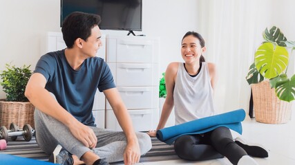 Asian young lover couple talking after play yoga and exercise at home background.Exercise for good health, increase flexibility And tighten the shape.