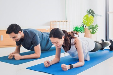 Asian young couple exercise together at home background.Concept of Exercise during the quarantine at home for preventing coronavirus and covid-19 infection.