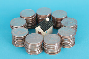 House model surrounded by coins