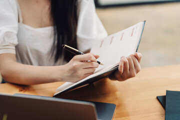 Close-up of a woman sitting and taking notes at the office.