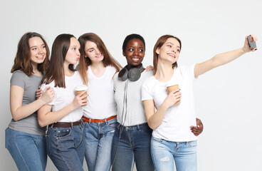 Obraz premium women of different ethnicities taking selfie and holding coffee to go cups