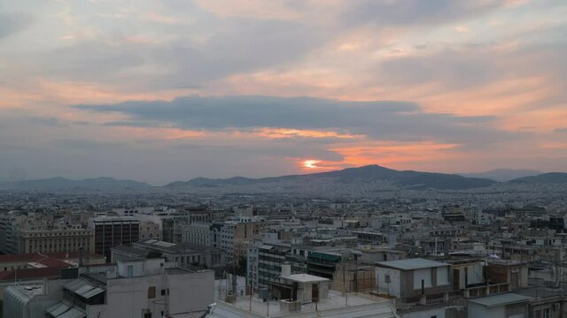 Sunset time lapse over Athens Greece city rooftops, day to night