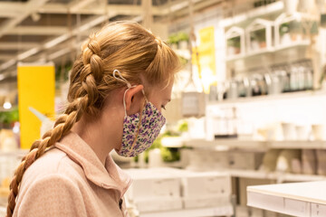 A girl wearing face mask in department store during COVID-19 pandemic.