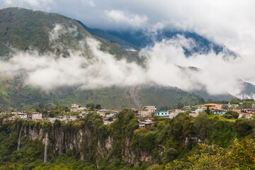 The Ecuadorian town of Baños de Aguasanta above a cliff with small waterfalls and in front of...