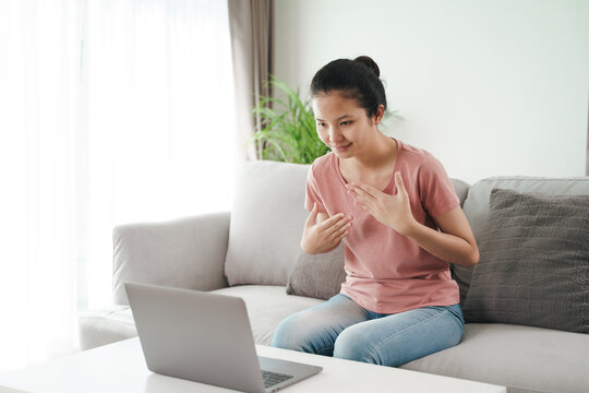 Young Asian Woman Deaf Disabled Using Laptop Computer For Online Video Conference Call Learning And Communicating In Sign Language..