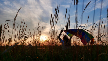 Bisexual, lesbian, woman, transgender in field holds LGBT flag on a background of the sky at sunset and celebrating a gay parade, Bisexuality Day or National Coming Out Day in pride month