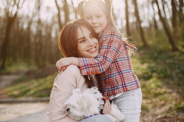 Mother with daughter in a spring forest with dog