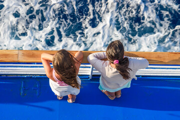 Beautiful Summer Scenery of two young children staring at the deep blue sea of aegean in Greece