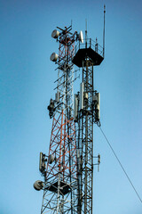 Cellular telecommunication towers against the blue sky. Vertical concept.